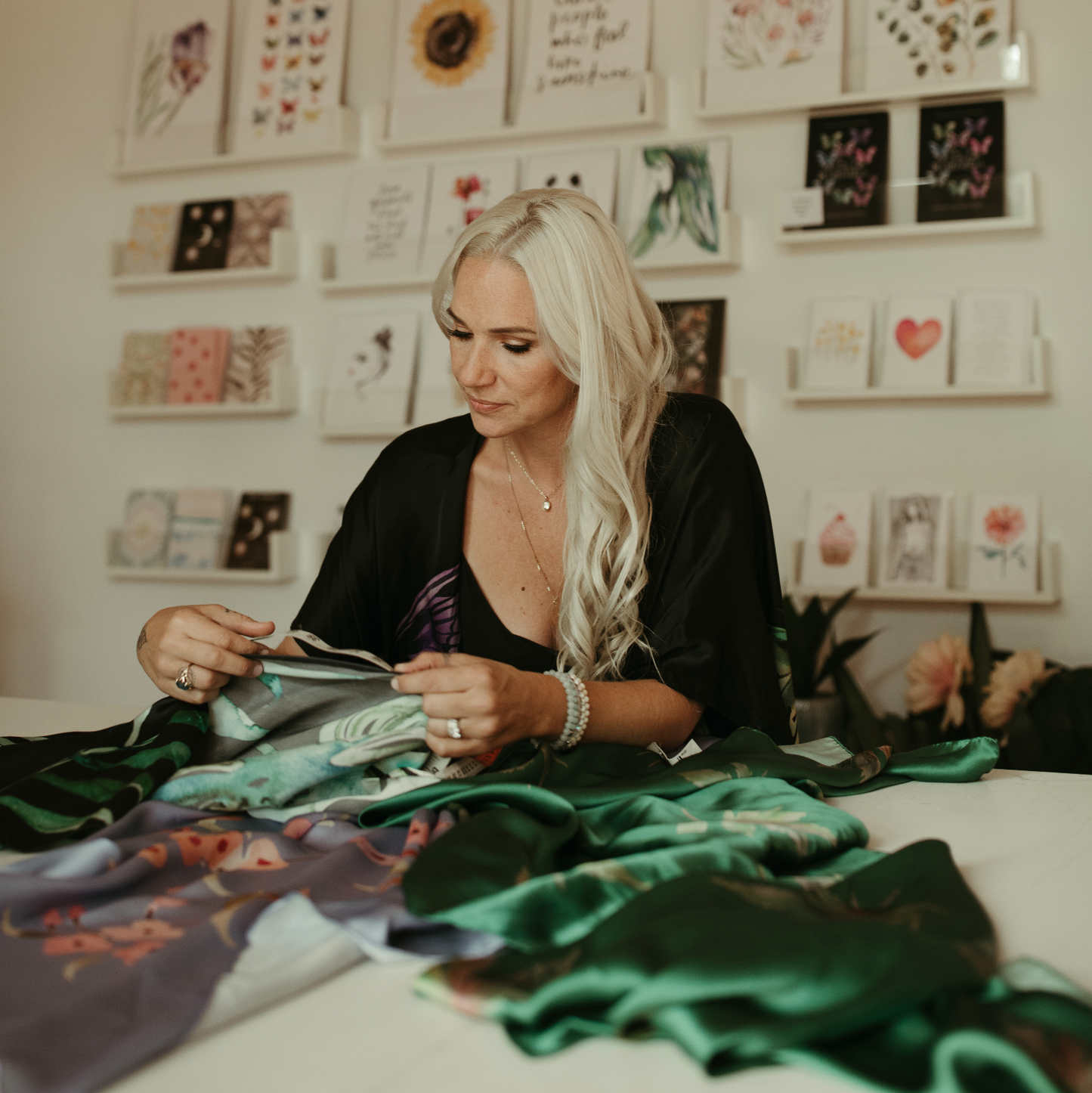 Marina Billinghurst on a project with fabric and art supplies in a room with 'Art of Marina' displayed.